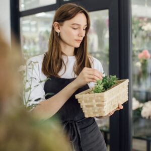 A young woman works in her flower shop. Small business concept.